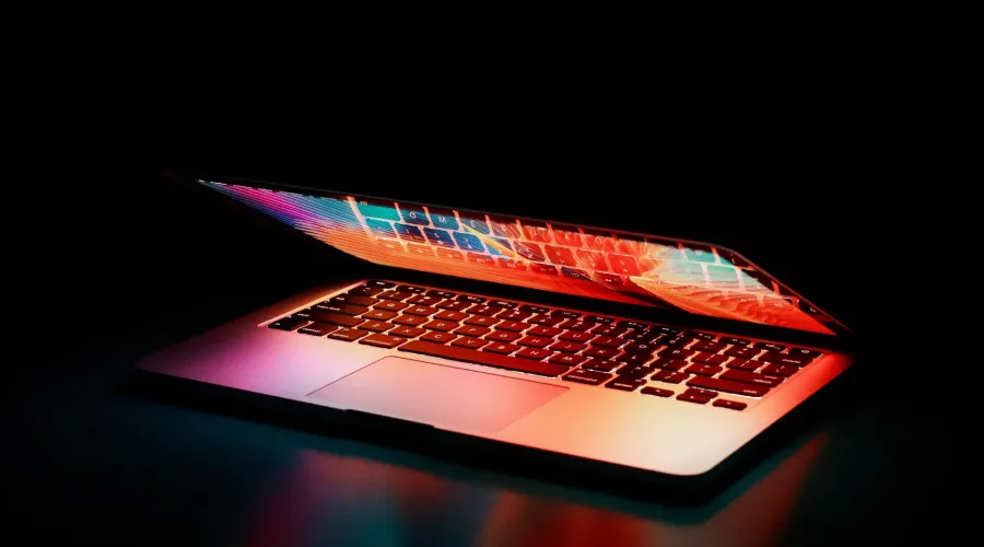 A partially open laptop glowing with neon light (Cyber security: Four tips for good data housekeeping)