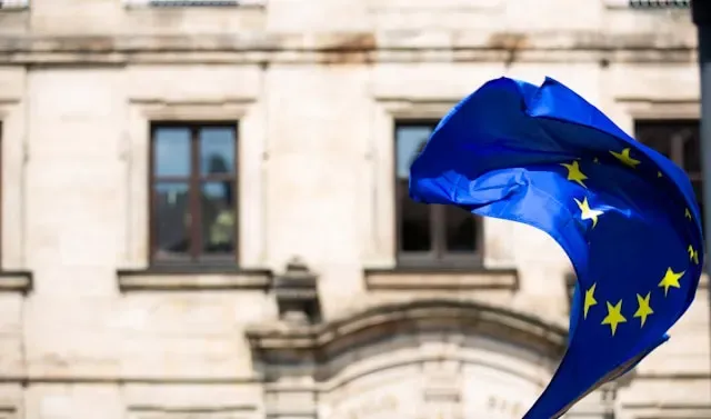 An EU flag flying over a building: DORA Digest August 2024 