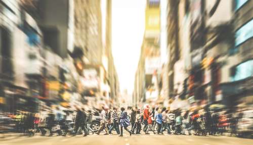 Commuters crossing a busy city street